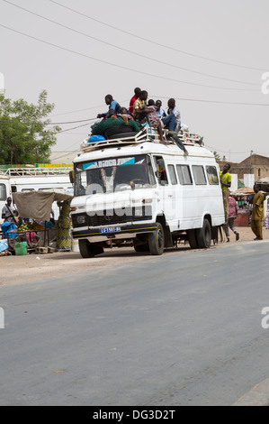 Sénégal, Touba. Transport local et la sécurité routière. Des jeunes hommes vont monter sur le dessus de la destination. Banque D'Images