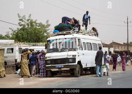 Sénégal, Touba. Transport local et la sécurité routière. Les jeunes hommes charger des marchandises sur top ; certains passagers vont monter. Banque D'Images