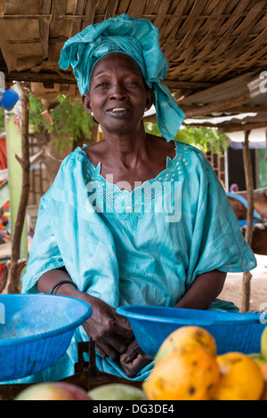 Sénégal, Touba. Femme vendant des mangues à la station de bus. Banque D'Images