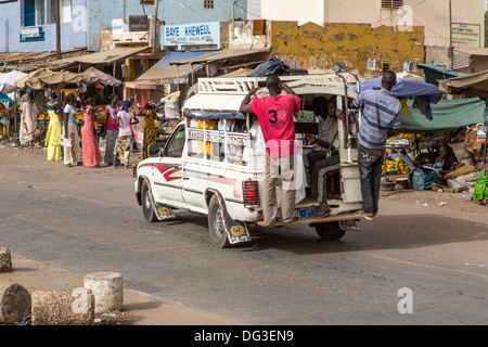 Sénégal, Touba. Le transport local. Pick-ups avec des jeunes hommes habituellement accroché sur le marchepied arrière, les passagers à l'intérieur. Banque D'Images