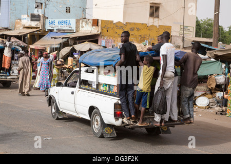 Sénégal, Touba. Le transport local. Pick-ups avec des jeunes hommes habituellement accroché sur le marchepied arrière, les passagers à l'intérieur. Banque D'Images
