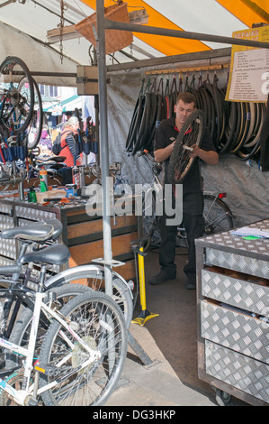 Homme travaillant dans la réparation de vélos au sein de décrochage Bikeman marché de Cambridge, England, UK Banque D'Images
