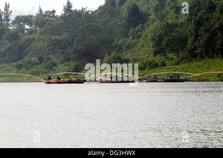 Flotille de bateaux de pêche qui travaillent ensemble avec les filets de chalutage poteaux étendu sur le lac Kivu au Rwanda l'Afrique Centrale Banque D'Images