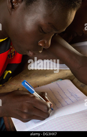 Sénégal, Touba. Garçon à la madrasa al-Azhar, une école pour les études islamiques, l'écriture en arabe dans son carnet. Banque D'Images