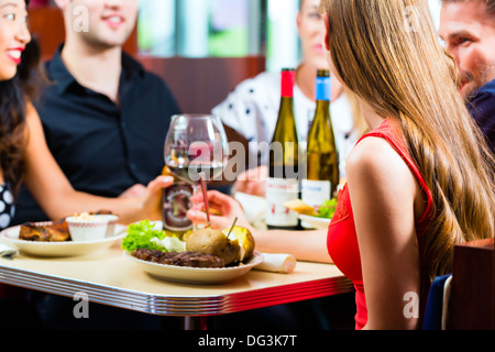 Des amis ou des couples eating fast food et de boire une bière et vin dans une salle à manger, cuisine américaine, restauration rapide Banque D'Images