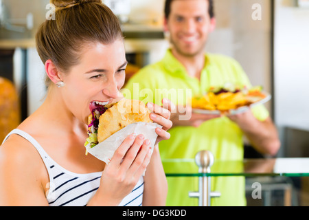 Döner Kebab - vendeur sympathique et femelle client dans un restaurant fast food turc, avec un pain pita fraîchement préparés ou kebab Banque D'Images