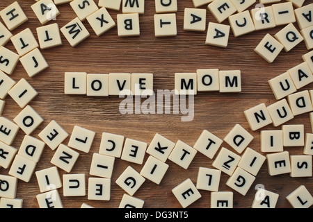 Lettres en plastique à partir d'une orthographe pour enfants jeu sur une table de bois sort 'Love Mum' Banque D'Images