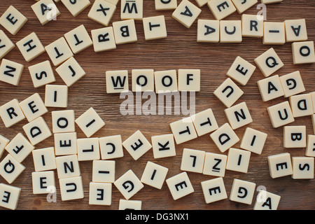 Lettres en plastique à partir d'une orthographe pour enfants jeu sur une table de bois sort 'Woof' Banque D'Images