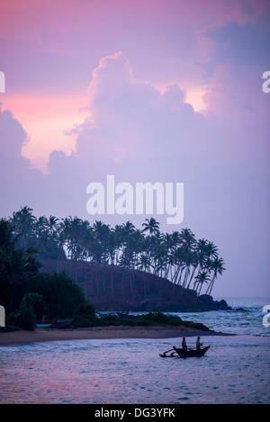 La plage de Mirissa, traditionnels du Sri Lanka outrigger bateau de pêche au lever du soleil, Côte Sud, Province du Sud, Sri Lanka, Asie Banque D'Images