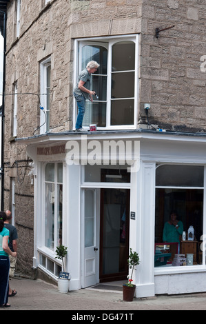 Hay-on-Wye dame mature une peinture blanche boutique en Powys Pays de Galles Banque D'Images