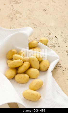 Pommes de terre Jersey Royal assis sur un linge blanc Banque D'Images