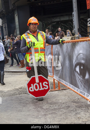 Female construction worker dirige le trafic à Times Square pour les camions de chantier. NYC Banque D'Images