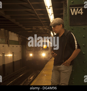 L'homme attend une rame de métro à la station West 4th Street à Greenwich Village, New York City. Banque D'Images