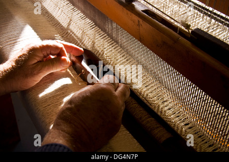 Le tissage traditionnel dans Eddie Doherty's atelier tweed à Ardara County Donegal Irlande. ici Eddie threads une navette Banque D'Images