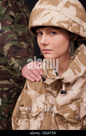 Femme Soldat désemparé être réconforté avec et main sur l'épaule par un soldat de sexe masculin. L'uniforme militaire britannique. Banque D'Images