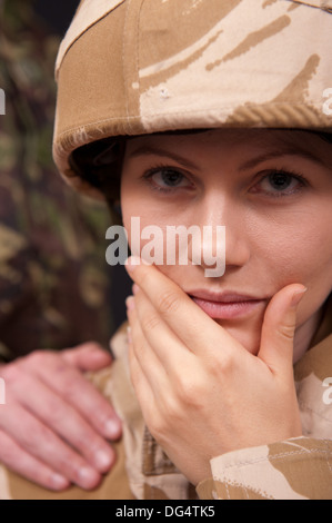 Femme Soldat désemparé être réconforté avec et main sur l'épaule par un soldat de sexe masculin. L'uniforme militaire britannique. Banque D'Images