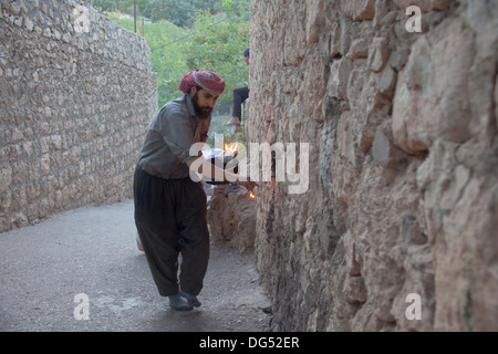 Lalish Yazidis, ville sainte dans le Nord de l'Iraq - saint homme allumage de la bougie d'huile rituelle dans le 365 lieu sacré dans la ville Banque D'Images