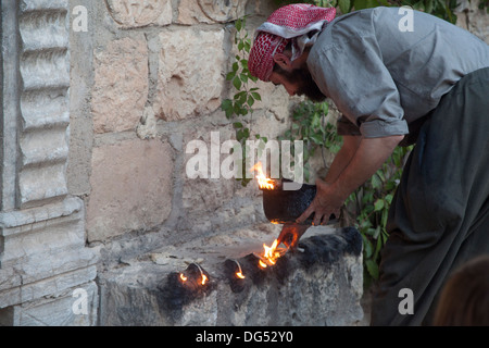 Lalish Yazidis, ville sainte dans le Nord de l'Iraq - saint homme allumage de la bougie d'huile rituelle dans le 365 lieu sacré dans la ville Banque D'Images