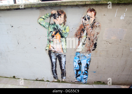 Graffiti de touristes masculins et féminins sur le mur dans le centre de Paris Banque D'Images