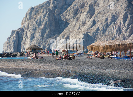 Santorin (thira), CYCLADES, en Grèce. La plage de sable volcanique noir dans la célèbre station balnéaire de Kamari. L'année 2013. Banque D'Images