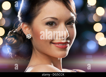 Femme en robe de soirée le port de boucles d'oreilles diamant Banque D'Images