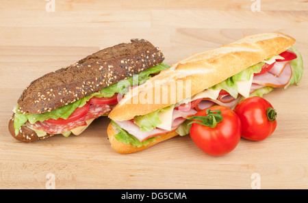 Des sandwichs avec de la viande et les légumes et les tomates de table en bois Banque D'Images