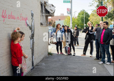 Queens, NY, USA . 14Th Oct, 2013. Les amateurs de street art affluent au voisinage de Woodside Queens à New York le lundi 14 octobre, 2013 pour voir la quatorzième tranche de l'art graffiti de Banksy, 'ce que nous faisons dans la vie résonne dans l'éternité". L'insaisissable artiste de rue, c'est la création d'œuvres autour de la ville chaque jour durant le mois d'octobre, accompagnée d'un message enregistré, vous pouvez entendre en appelant le numéro 1-800-656-4271 suivi de #  et le nombre d'œuvres. (© Frances M. Roberts) Credit : Frances Roberts/Alamy Live News Banque D'Images