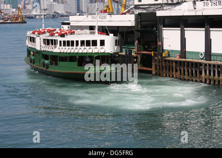 Une Star solaire, l'une des flotte Star Ferry qui fait la navette entre l'île de Hong Kong et Kowloon . Accostage à Star Ferry Pier Tsimshatsui Banque D'Images