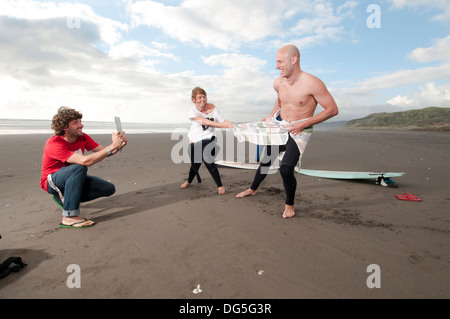 Ami de filmer les amis ayant un rire lors de l'obtention de changé avant qu'une surf Banque D'Images