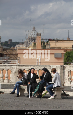 Des gens assis sur un banc de la place du Quirinal à Rome, Italie Banque D'Images