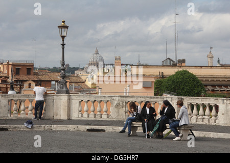 Des gens assis sur un banc de la place du Quirinal à Rome, Italie Banque D'Images