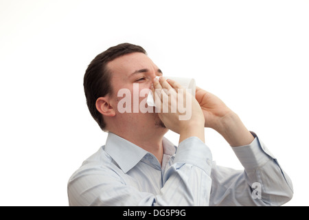 Jeune homme soufflant son nez en nappes Banque D'Images