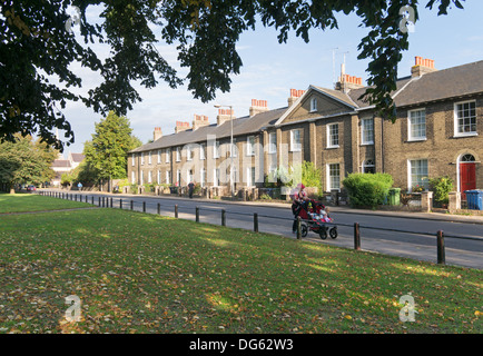 Woman pushing buggy passé feuilles mortes nouveau Square Cambridge, England, UK Banque D'Images