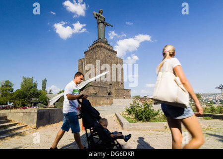 La famille arménienne passe devant l'immense statue de la mère Arménie et musée militaire à Victory Park, Yerevan, Arménie Banque D'Images