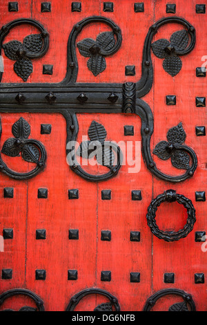 Détail d'une porte de l'église décorée rouge noir avec détails en métal Banque D'Images