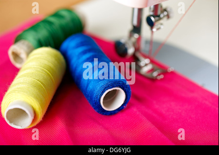 Close up de threads sur tissus et machine à coudre. Shalow DOF. Focus sélectif. Se concentrer sur les fils bleu. Banque D'Images