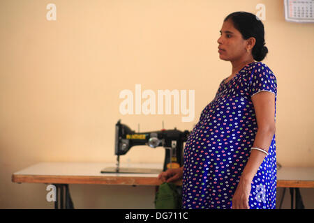 Anand, Gujarat, Inde. 20e Août, 2013. Sharda Solanki, une mère porteuse qui est enceinte de 8 mois apprend machine à coudre à la maison. Les couples de partout dans le monde se dirigent vers les rues poussiéreuses de l'arrière-pays de l'Inde à la recherche d'un enfant biologique par le biais de substitution. La maternité de substitution à des fins commerciales n'est pas autorisé dans de nombreux pays, et cela a été l'occasion pour l'Inde pour tirer profit de la maternité de substitution comme une région en pleine croissance de l'industrie du tourisme médical en plein essor a une valeur annuelle de 2,3 milliards de dollars. Plus de 680 bébés sont nés à Akansha clinique pour les mères porteuses, Banque D'Images