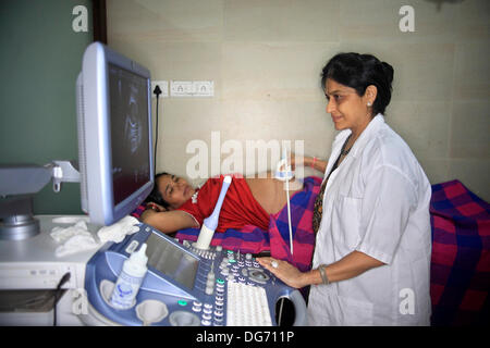 Anand, Gujarat, Inde. 20e Août, 2013. Le Dr NAYANA PATEL examine une mère porteuse à sa clinique à Anand. Les couples de partout dans le monde se dirigent vers les rues poussiéreuses de l'arrière-pays de l'Inde à la recherche d'un enfant biologique par le biais de substitution. La maternité de substitution à des fins commerciales n'est pas autorisé dans de nombreux pays, et cela a été l'occasion pour l'Inde pour tirer profit de la maternité de substitution comme une région en pleine croissance de l'industrie du tourisme médical en plein essor a une valeur annuelle de 2,3 milliards de dollars. Plus de 680 bébés sont nés à Akansha clinique pour les mères porteuses, pour la plupart de villages pauvres, ove Banque D'Images