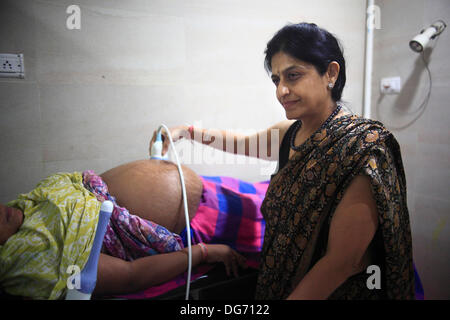 Anand, Gujarat, Inde. 20e Août, 2013. Le Dr NAYANA PATEL examine une mère porteuse à sa clinique à Anand. Les couples de partout dans le monde se dirigent vers les rues poussiéreuses de l'arrière-pays de l'Inde à la recherche d'un enfant biologique par le biais de substitution. La maternité de substitution à des fins commerciales n'est pas autorisé dans de nombreux pays, et cela a été l'occasion pour l'Inde pour tirer profit de la maternité de substitution comme une région en pleine croissance de l'industrie du tourisme médical en plein essor a une valeur annuelle de 2,3 milliards de dollars. Plus de 680 bébés sont nés à Akansha clinique pour les mères porteuses, pour la plupart de villages pauvres, ove Banque D'Images