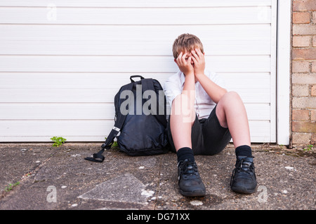 Un garçon de 10 à la triste et déprimé dans son uniforme de l'école montrant les effets de l'intimidation au Royaume-Uni Banque D'Images