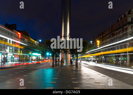 Le point de vue de la spire de Dublin monument situé sur l'O'Connell street au crépuscule. Passant du trafic depuis les sentiers de lumière en arrière-plan. Banque D'Images