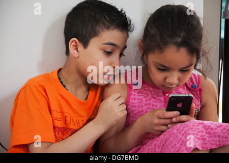 Les enfants syriens jouer sur un iPhone à Chatila, un camp de réfugiés palestiniens à Beyrouth. Banque D'Images