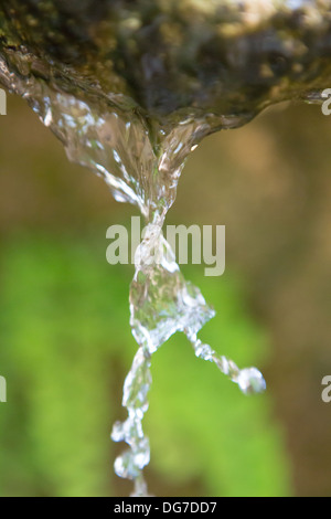 Close up de déverser de l'eau pure dans un moment privilégié de circulation avec un arrière-plan flou vert , en Grèce, 2013. Banque D'Images