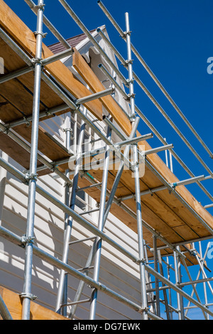 Un portrait de l'échafaudage contre un bâtiment de deux étages en cours de réparation et de rénovation. Banque D'Images