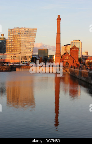 La station de pompage et d'autres bâtiments reflètent dans la lumière du soir dans le cadre de l'Albert Dock, Liverpool, Merseyside. Banque D'Images