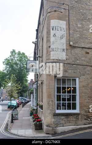 Vieille enseigne délabrées peintes sur le mur de pierre d'une boutique à Woodstock, la publicité "vues et cartes postales de Blenheim'. Banque D'Images