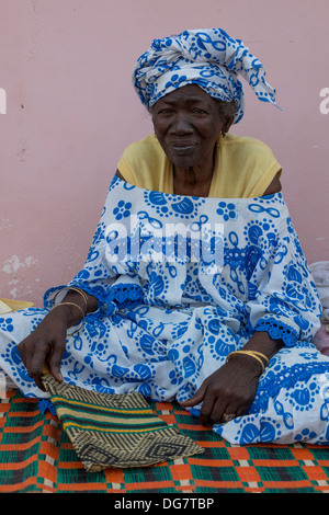 Sénégal, Saint Louis. Vieille Femme Sénégalaise avec ventilateur assise sur son porche. Banque D'Images