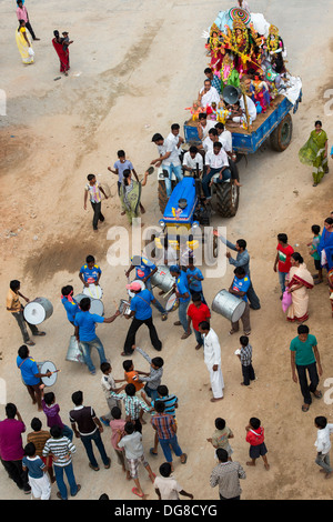 Des statues de la Déesse indienne sur un tracteur et remorque avec les garçons de tambour et danser à un festival de Dasara. L'Andhra Pradesh, Inde Banque D'Images