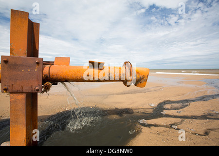 La vidange des eaux usées brutes directement sur la plage à partir d'un tuyau d'eaux usées provenant d'un caravan park à Kilnsea, rejette Point, Yorkshire, UK. Banque D'Images