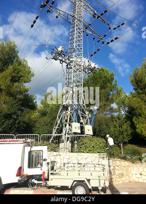 Électriciens travailler sur un pylône haute tension photographié en Israël Banque D'Images